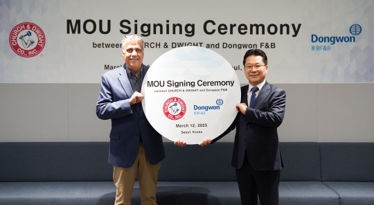 지난 12일 서울시 서초구 동원그룹 본사에서 강용수(오른쪽) 동원F&B DNB본부장과 아룬 히라난다니(왼쪽) 처치앤드와이트 부사장과 업무 협약을 맺고 기념 촬영을 하고 있다. 동원F&B 제공